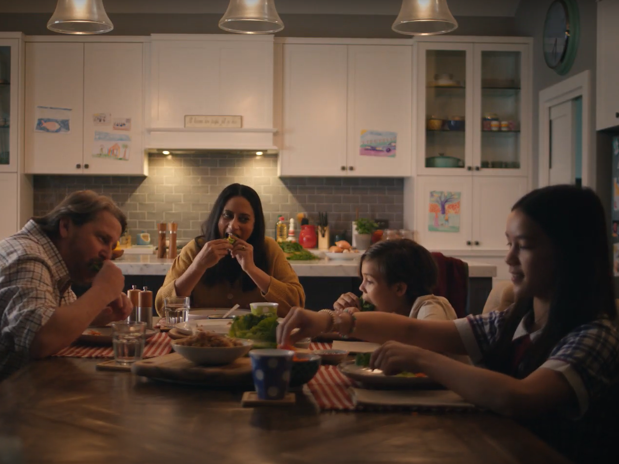 Screenshot of Australian Pork san choy bow TV commercial. Family of 4 sitting around dinner table eating pork san choy bow.