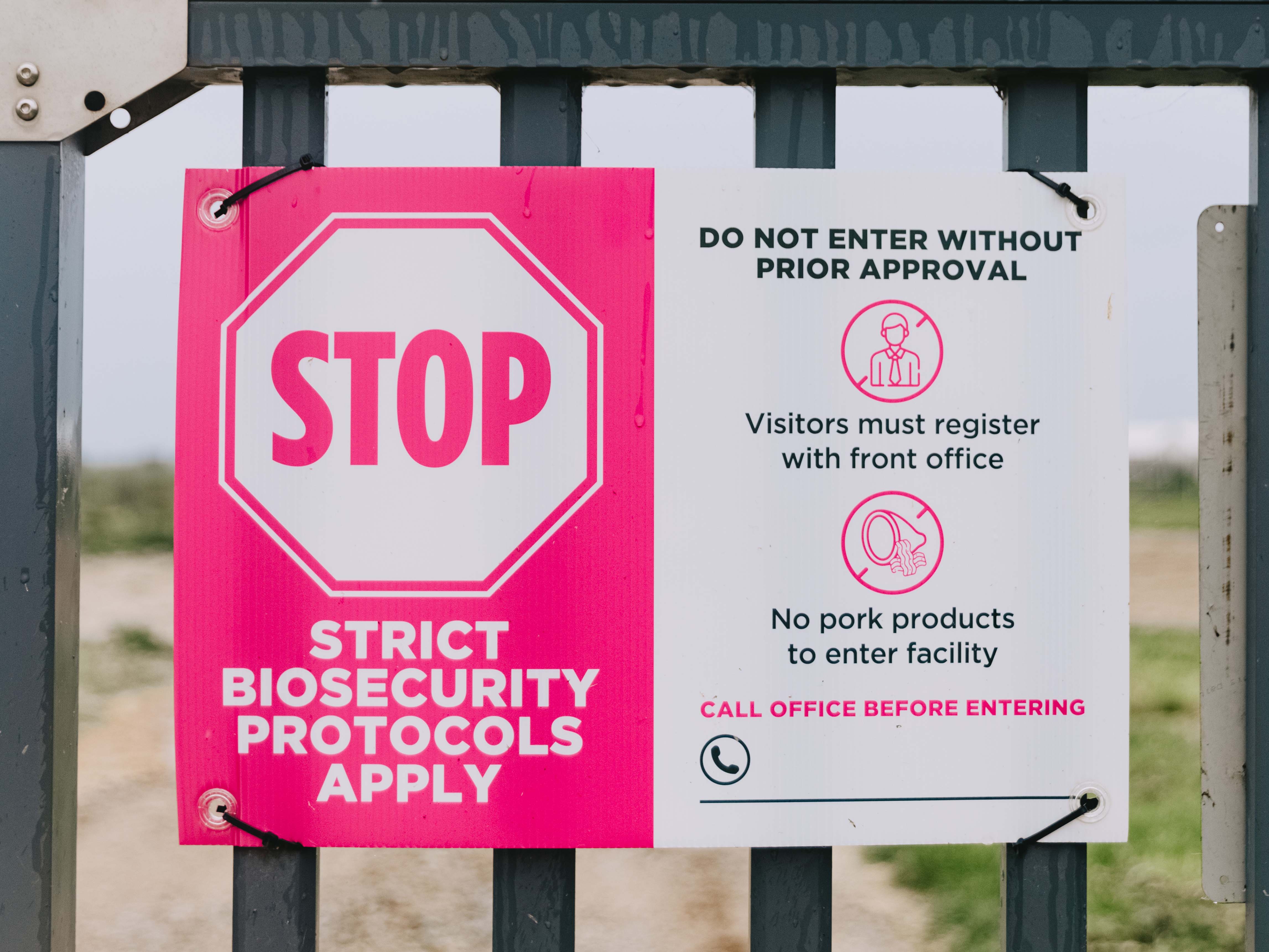 Biosecurity sign on a black metal fence